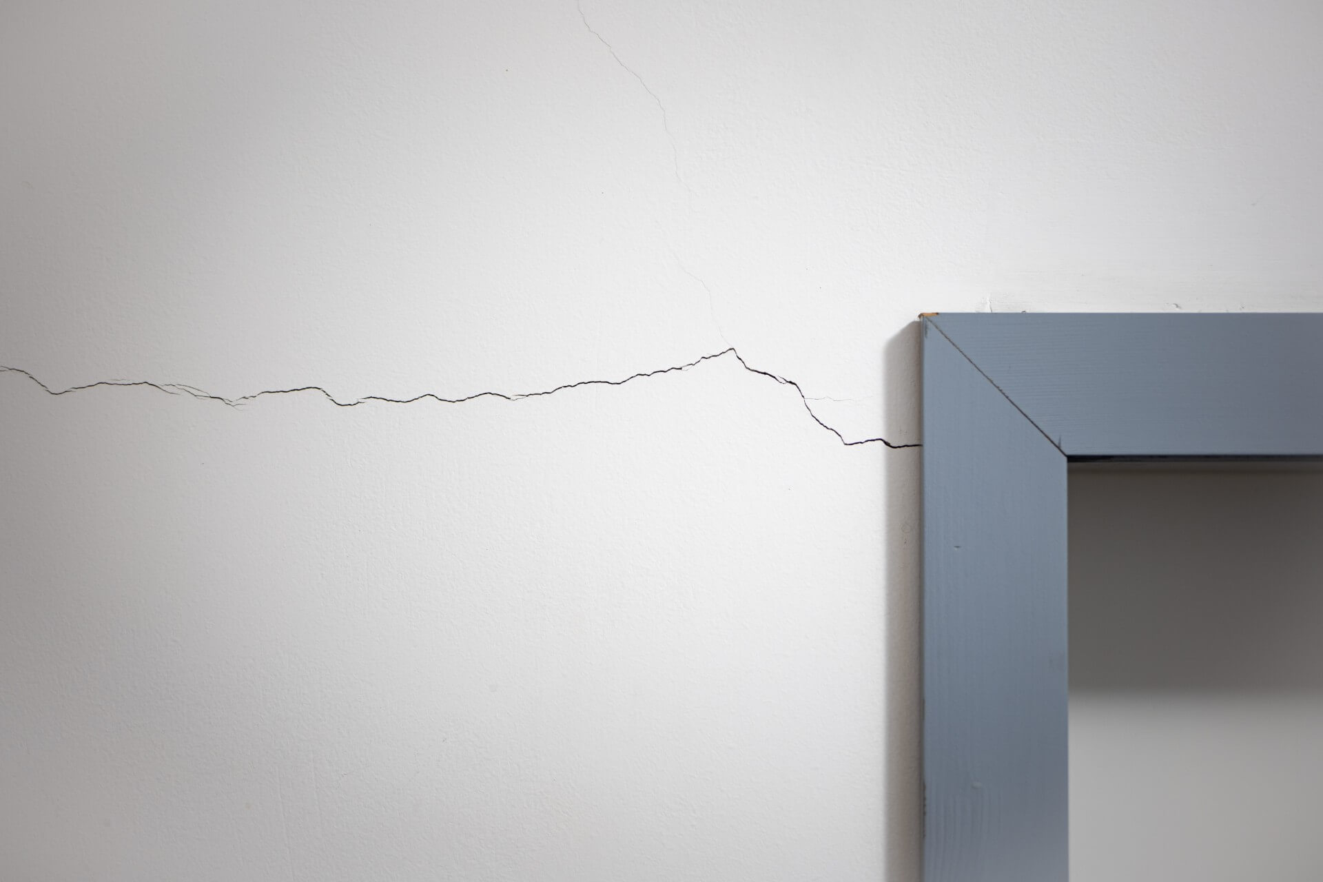 Indvendig sætningsskade – lodret revne i pudset væg ved vindue
