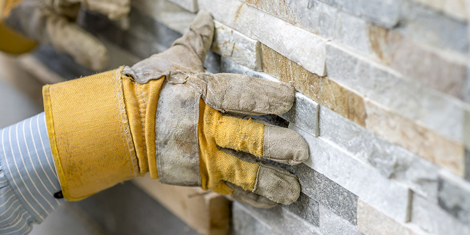 Afskallet flisevæg som tegn på fugtskade eller underliggende konstruktionstab